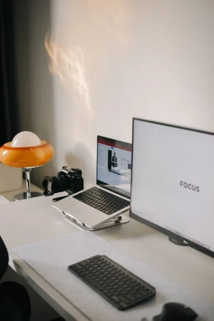 Dual monitors on a desk, showcasing web design in a modern office setting.
